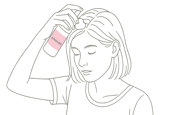 頭皮にミノキシジル外用薬を塗布する女性
